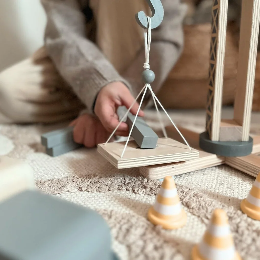 Mamabrum, drewniany plac budowy z dużym dźwigiem samojezdnym i pojazdami, dźwigiem samojezdnym, stożkami drogowymi, platformą z materiałami budowlanymi Żuraw dziecięcy Żuraw zab